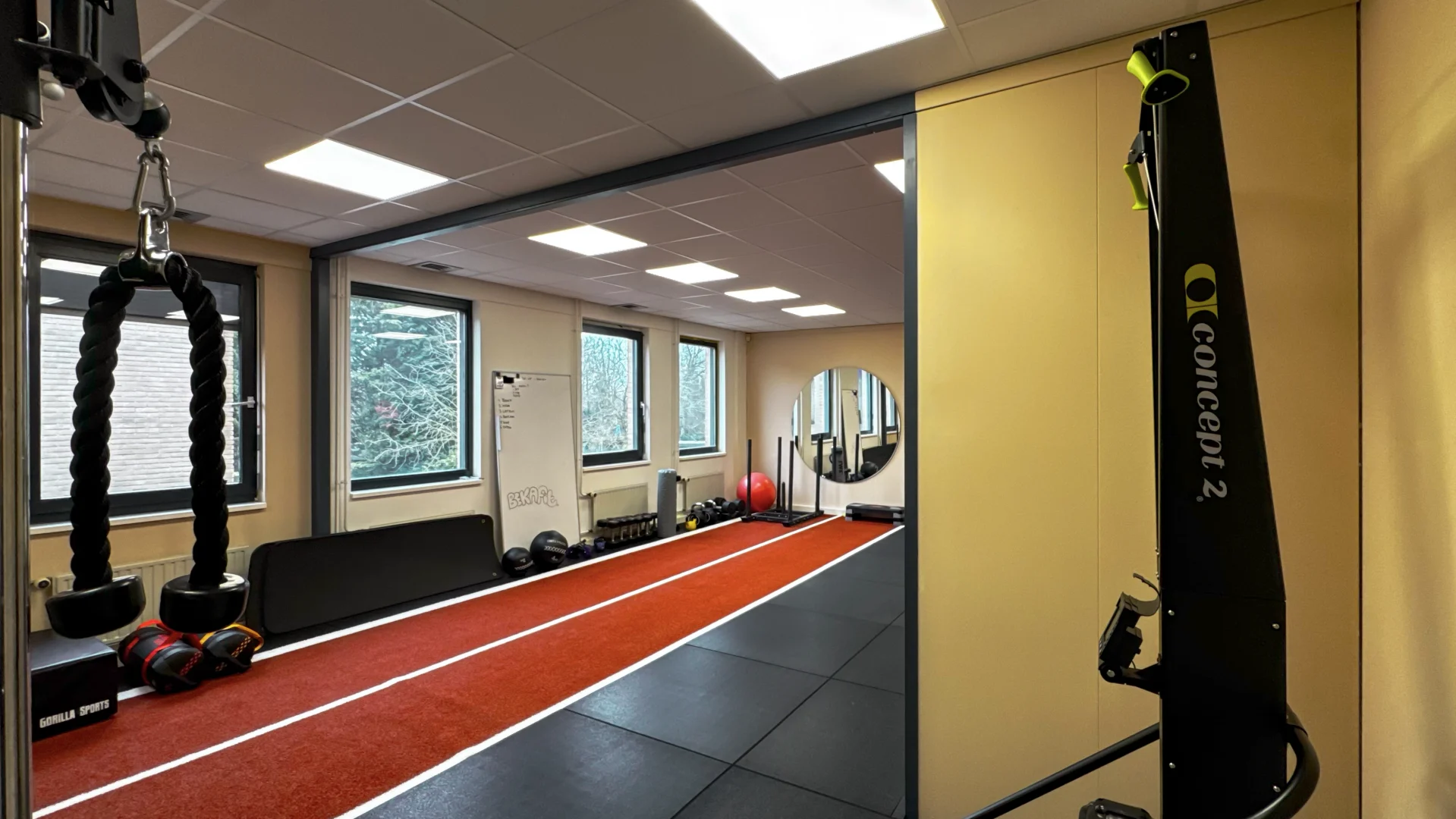 De trainingsruimte van Bekafit in Goes met de rode sprintbaan, daglicht en apparatuur